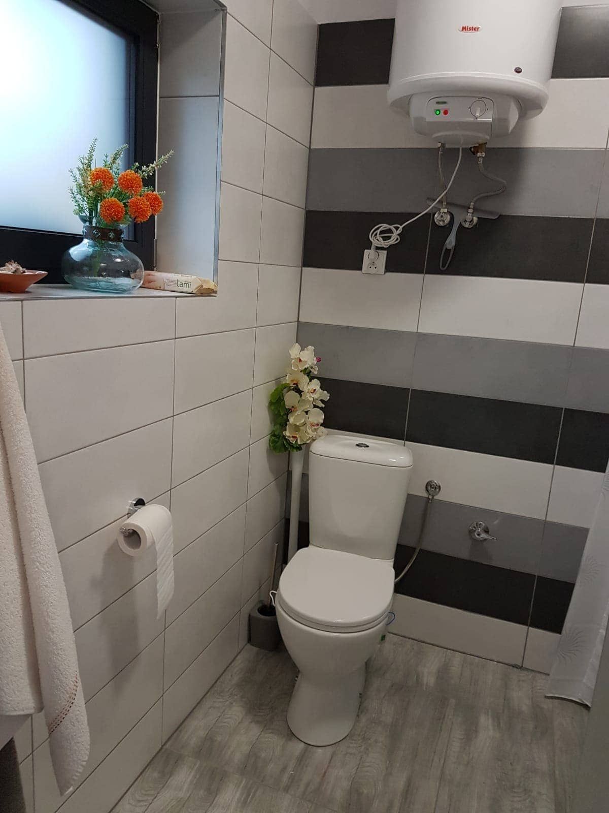 Łazienka apartamentu wykończona biało-szarymi płytkami