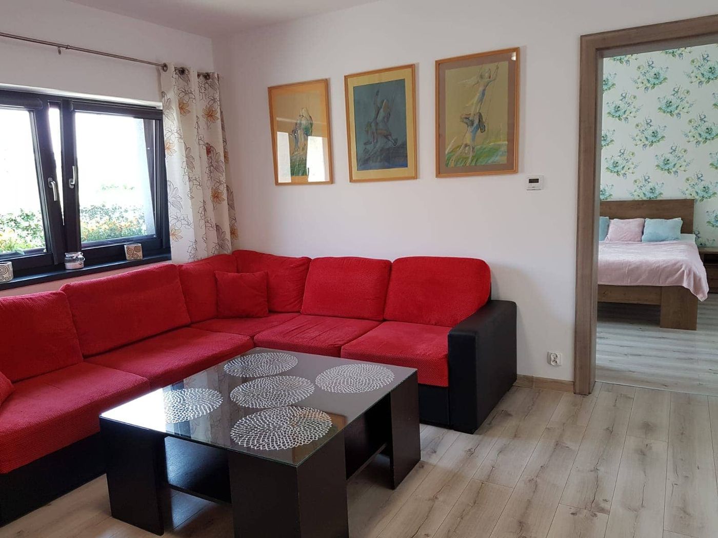 Część wypoczynkowa apartamentu — narożnik, stolik kawowy i obrazy