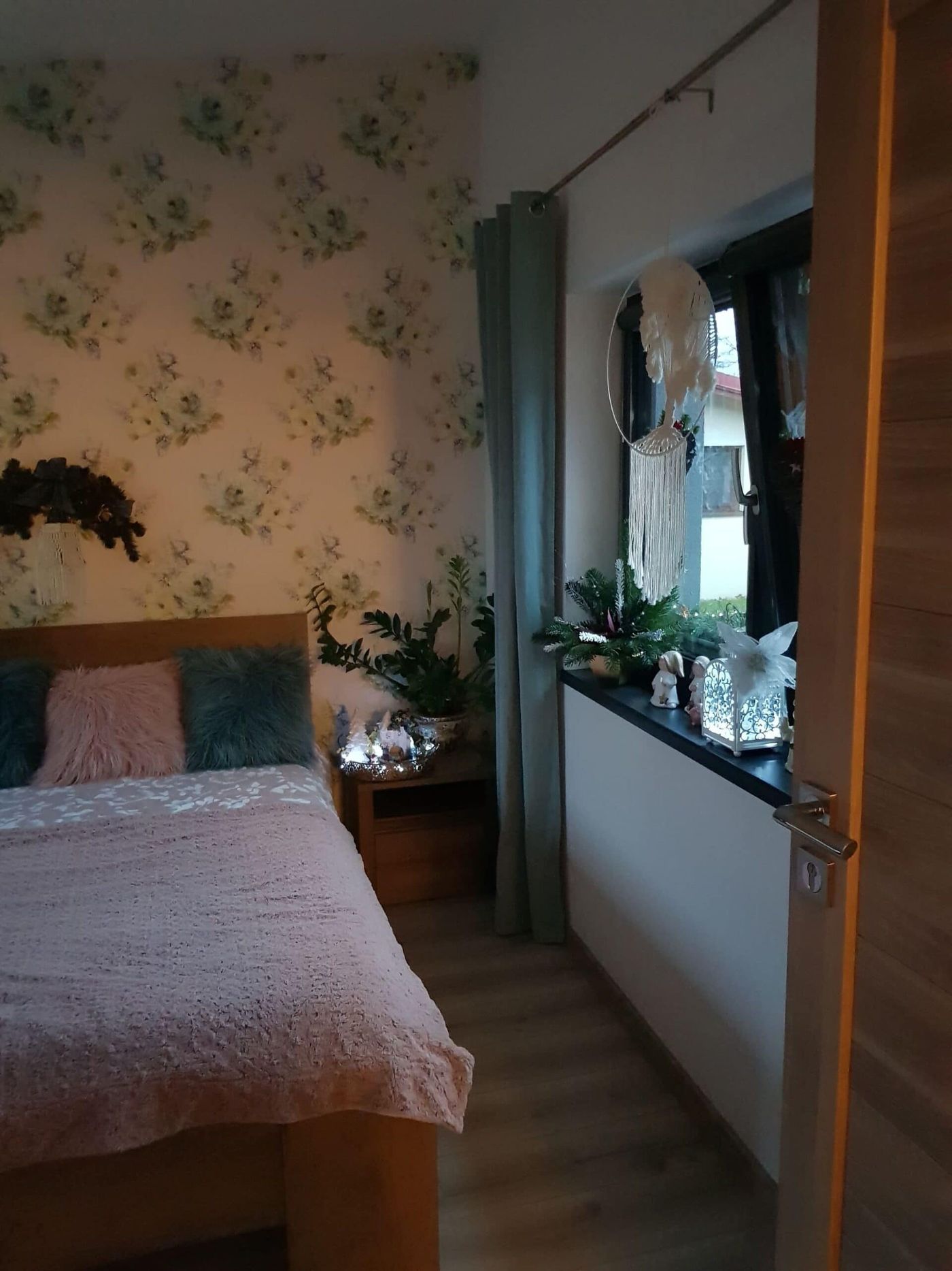 Jasny pokój z kwiecistą tapetą, dekoracjami i lustrem
